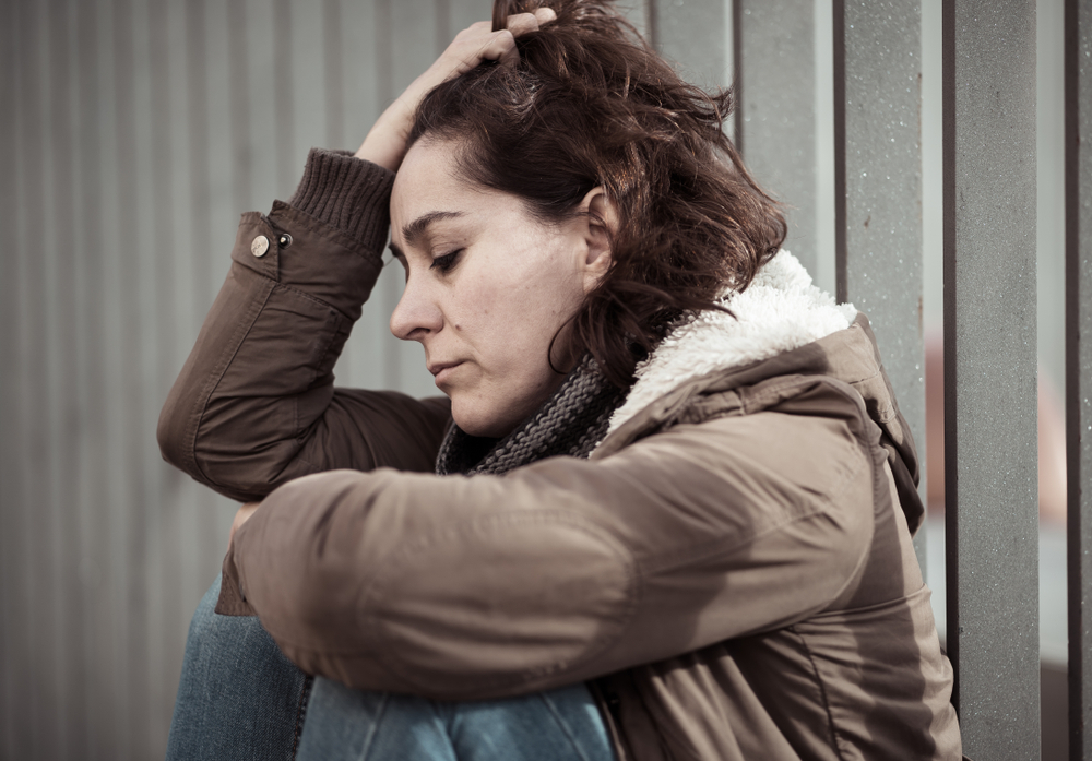 depressed woman sat on street