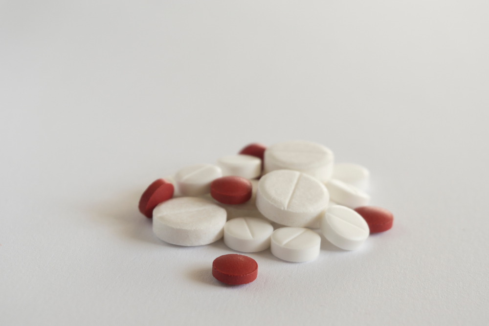 pile of red and white pills on white background