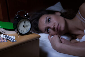 woman awake nighttime with pills