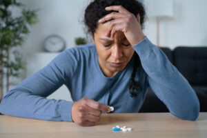 depressed woman holding medication